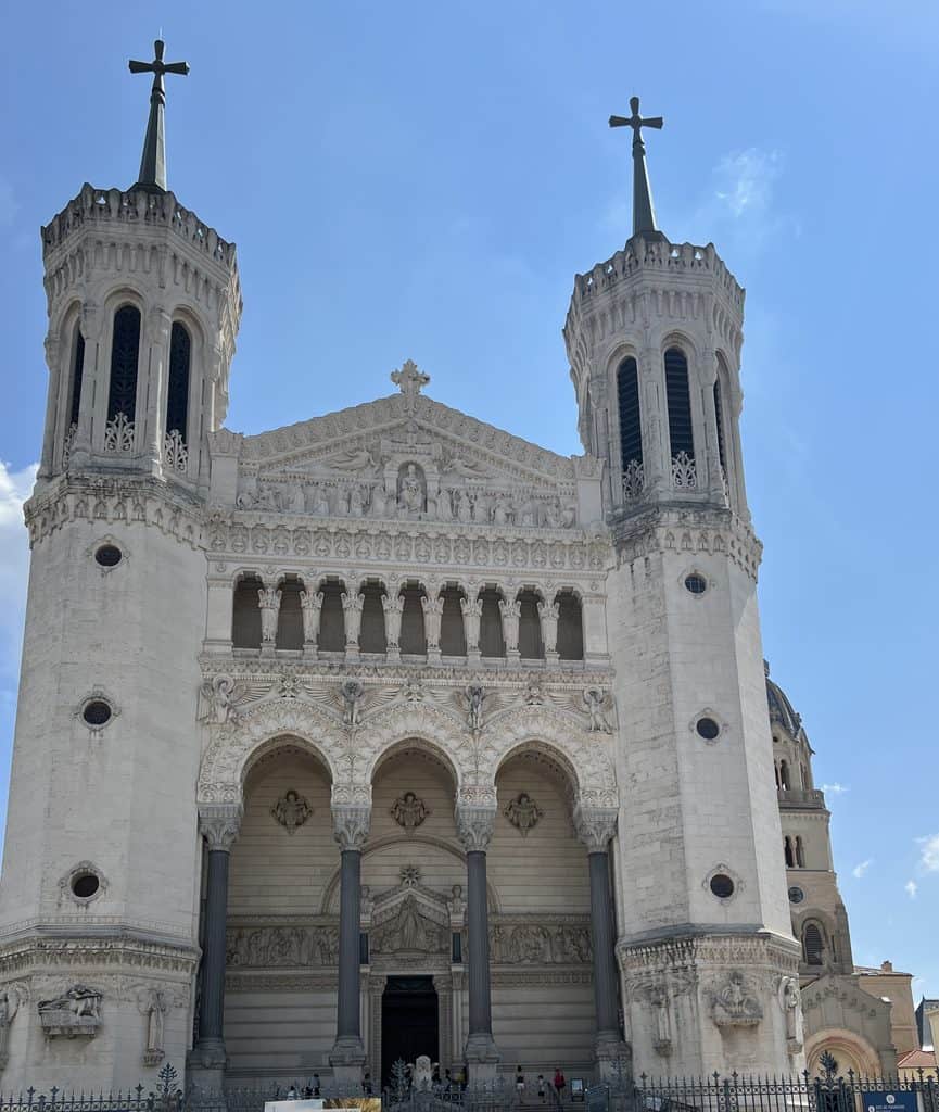 White facade and spires of Notre-Dame de Fourvière Basilica overlooking the UNESCO World Heritage district of Lyon, France.