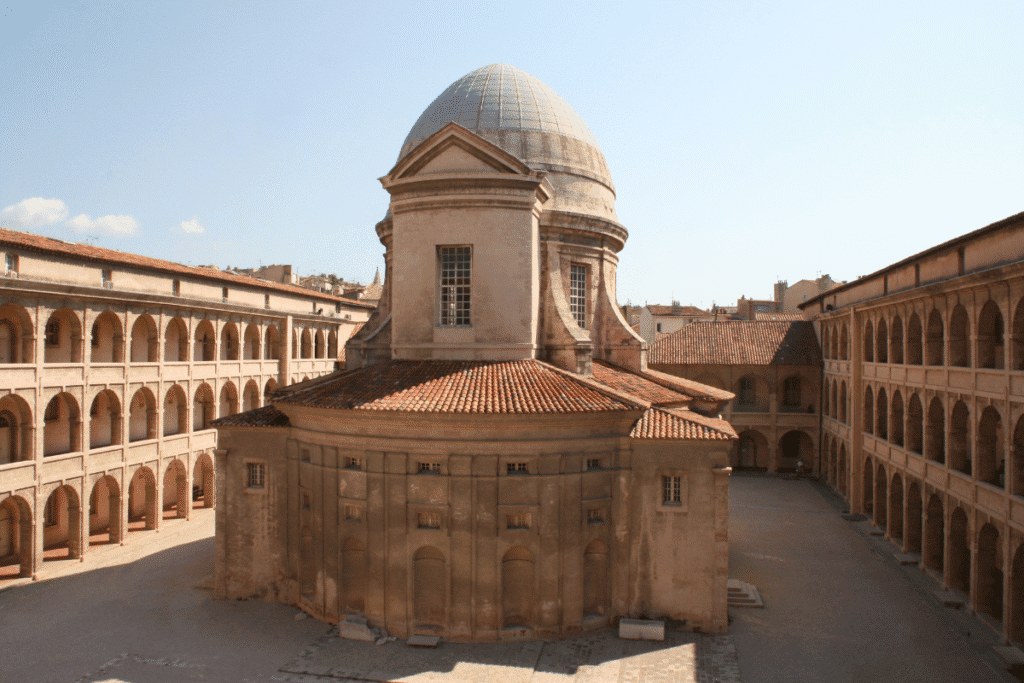 Courtyard view of the Vieille Charité in the Le Panier district of Marseille, featuring its central domed chapel and surrounding arcaded galleries, a historic site to include on any Marseille itinerary.
