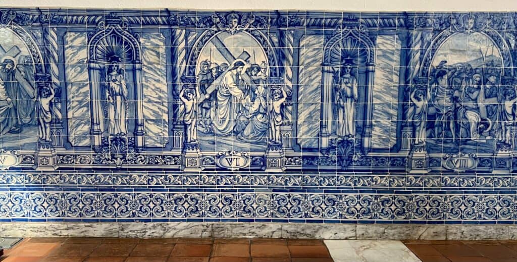 Traditional blue and white azulejos depicting scenes from the Stations of the Cross inside a Lisbon chapel, offering a beautiful and reflective cultural experience for any Lisbon itinerary.