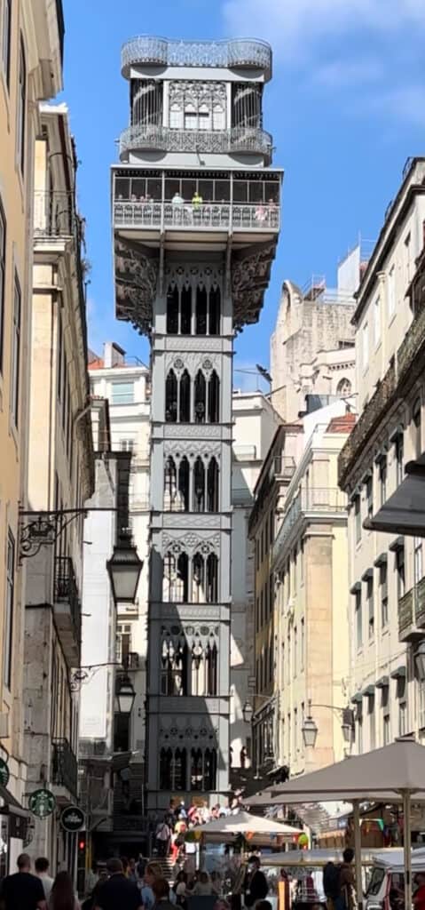 The ornate neo-Gothic Elevador de Santa Justa rising between Lisbon’s historic buildings under a clear blue sky, a must-see attraction included in the perfect Lisbon itinerary.