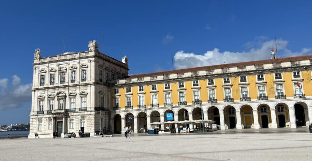 Praca do Comercio features a long yellow building with arched walkways facing a wide open square near the waterfront. This historic plaza is a central stop on any 3 day itinerary Lisbon.