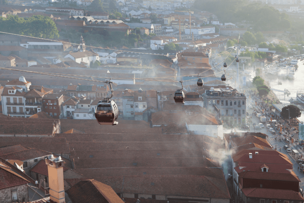 Cable cars glide over Porto’s red rooftops and the riverside district with light haze in the air. Riding the gondola offers a unique perspective and is one of the fun things to do in Porto.