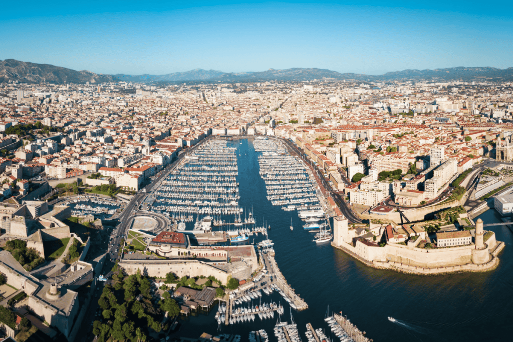 View of the Vieux-Port natural harbor in Marseille filled with boats and historic city buildings.