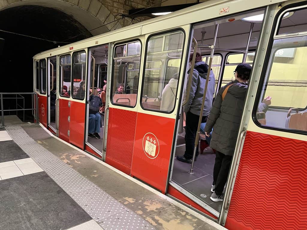 Red Fourviere Funicular departing from Basilica and heading down the hill to the station in Vieux Lyon