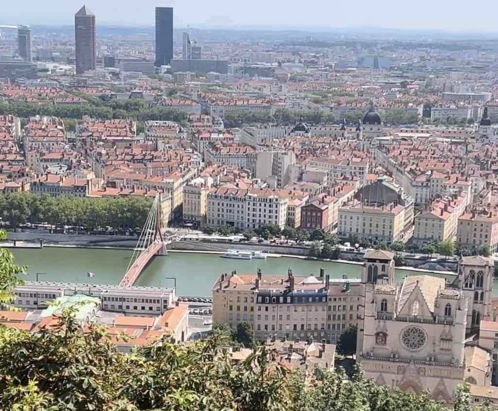 Panoramic city view of Lyon, France from Fourvière Hill showing the Saône River, red-roofed buildings, and the Presqu'île.