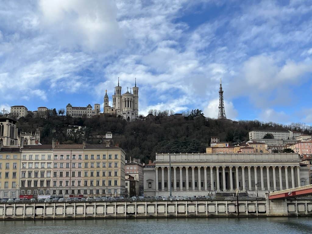 View of Notre Dame de Fourviere and Metallic Tower from Vieux Lyon with the river in the foreground.